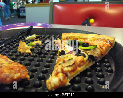 Unfinished pizza left on serving platter at restaurant Stock Photo