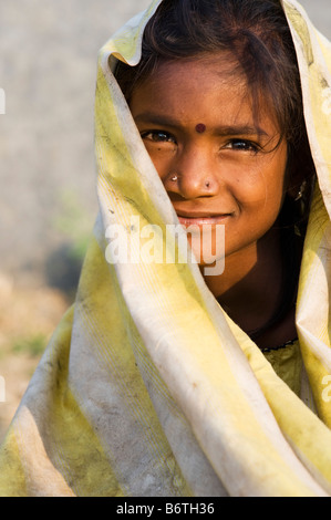 Poor nomadic indian girl wrapped in a dirty sheet smiling. Portrait. Andhra Pradesh, India Stock Photo