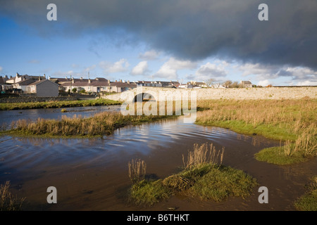 Salt marsh by tidal Afon Ffraw River on west coast with old stone bridge (Hen Bont) to village. Aberffraw Anglesey North Wales UK Britain Stock Photo