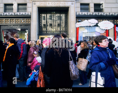 New York City Christmas shoppers on a crowded Fifth Avenue. Busy street scene in front of Saks Fifth Avenue store. USA Stock Photo