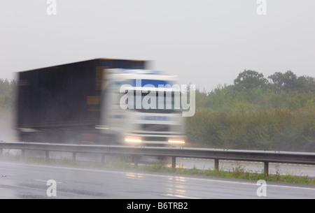 Lorry traffic in heavy rain on a dual carriageway road the A35 in Oxfordshire Stock Photo
