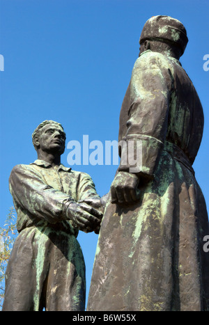 Socialist Realism sculpture of worker and soldier shaking hands Stock Photo