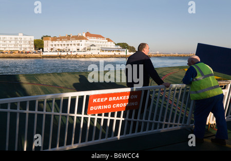 A view across Poole harbour of the Haven Hotel, Sadbanks, from the back of the chain link ferry. Dorset. Ferry workers talking. Stock Photo