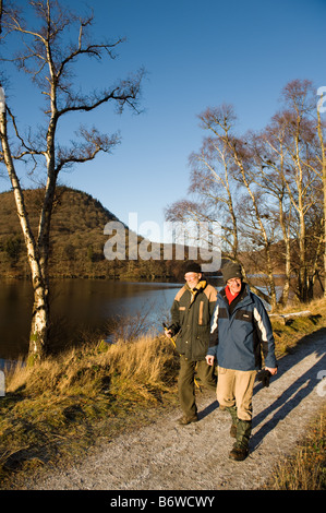 2 men people walking along the Elan Valley trail public footpath Powys mid wales January 2009 Stock Photo