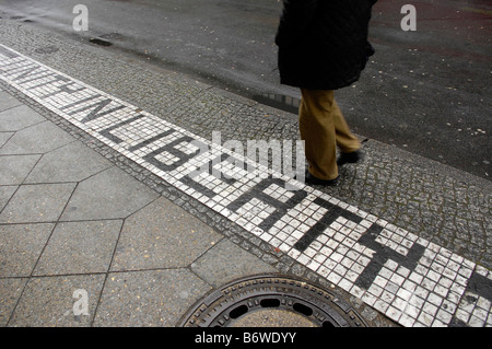 pavement sidewalk checkpoint charlie berlin germany deutschland travel tourism tiles unity in liberty pedestrian passer by Stock Photo