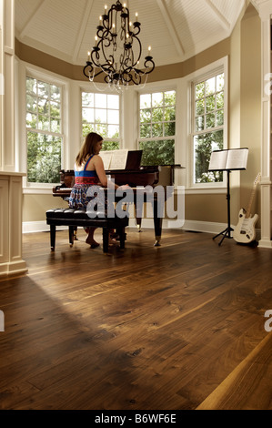 Young woman playing a grand piano Stock Photo