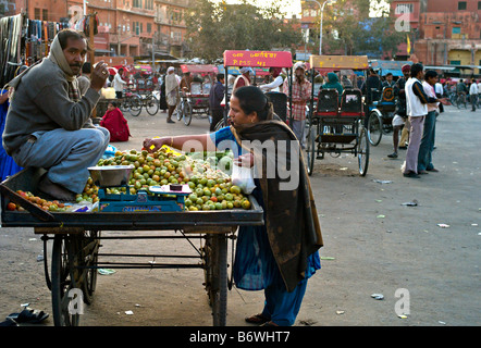 INDIA JAIPUR RAJASTHAN Indian woman buying tomatoes from a cart in the market in Jaipur Stock Photo