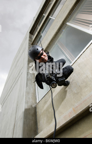SWAT Team Officer Rappelling from Building Stock Photo
