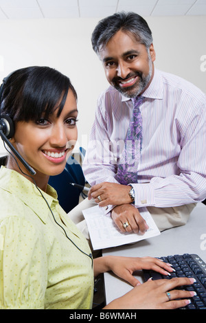Two customer service representatives working on a computer Stock Photo ...