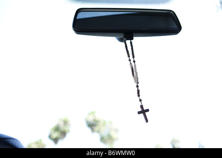 Rosary hanging from rear view mirror of car Stock Photo