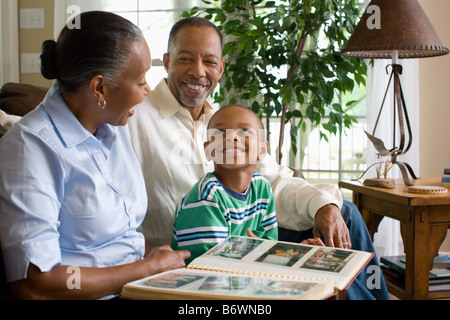 Grandparents and their grandson looking at a photo album Stock Photo