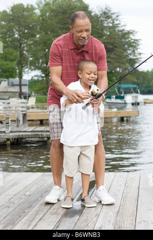 A grandfather teaching his grandson to fish Stock Photo