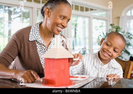 A grandmother and grandson painting a birdhouse Stock Photo