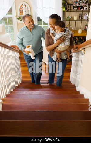 Grandparents carrying their grandson upstairs Stock Photo