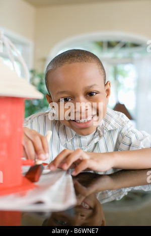 A boy painting a birdhouse Stock Photo