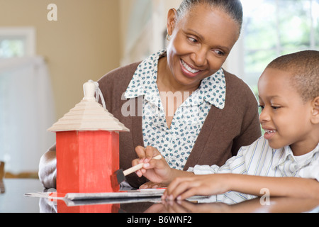 A grandmother and grandson painting a birdhouse Stock Photo