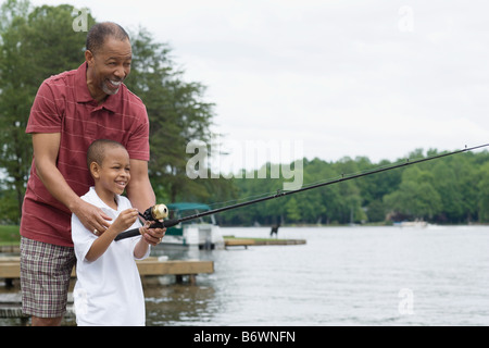 A grandfather teaching his grandson to fish Stock Photo