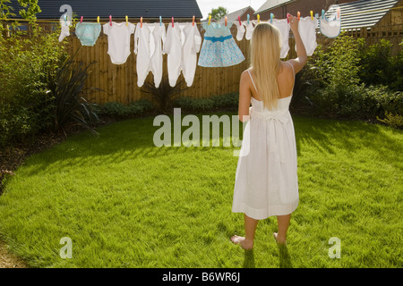 Woman with baby clothes on clothes line Stock Photo