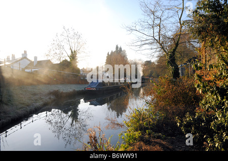 Narrowboats with smoking chimneys on the River Wey Navigation at the New Inn in Send Surrey on a cold winter's morning. Stock Photo