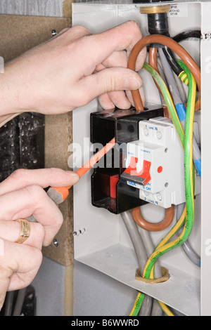 An electrician fixing a fuse box Stock Photo