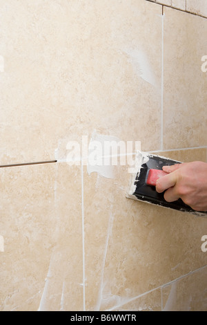 A decorator grouting tiles Stock Photo