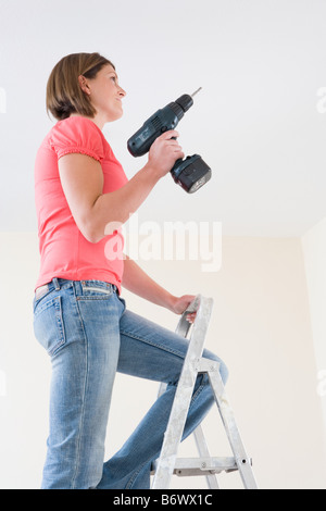 A young woman holding an electric drill Stock Photo