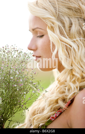 Portrait of a young woman holding a bunch of flowers Stock Photo