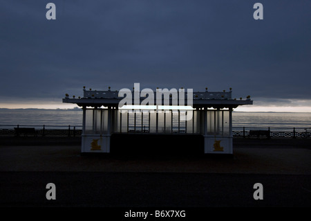 A promenade shelter against a darkening sky on the prom on Brighton and Hove seafront Stock Photo