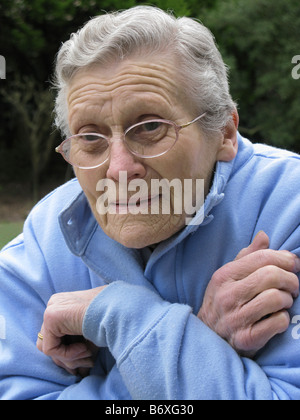 elderly woman feeling very cold due to freezing temperatures Stock Photo
