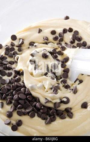 Mixing chocolate chips into raw cake mix. The batter mixture of eggs, butter, sugar and flour was then used to make cupcakes. Stock Photo