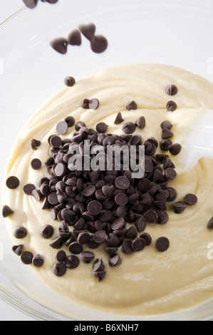 Dropping chocolate chips into raw cake mix. The batter mixture of eggs, butter, sugar and flour was then used to make cupcakes. Stock Photo