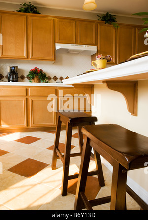 Two wooden stools at breakfast bar in kitchen Stock Photo