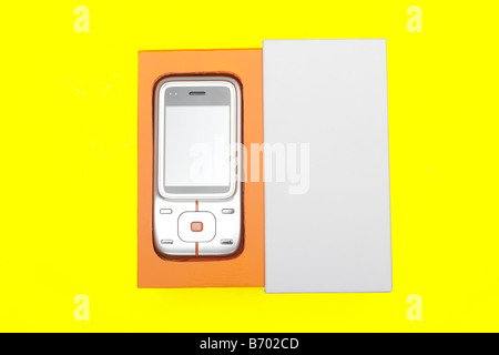 Mobile phone inside an orange and white cardboard package box on a yellow background Stock Photo