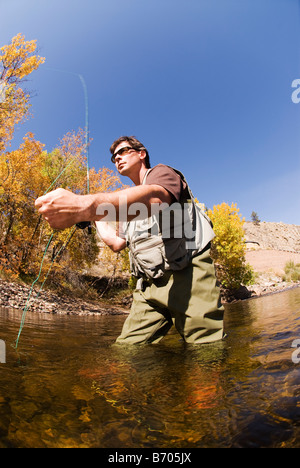 A man fly fishing in the Cache La Poudre River in autumn near Fort Collins, Colorado. Stock Photo