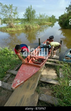 Suriname, Matapica National Park. Transport in small canoe in marsh land. Crossing little dike. Stock Photo