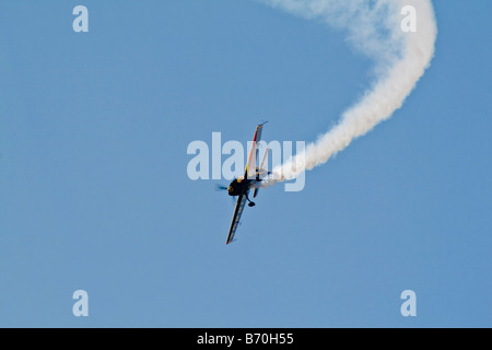 A stunt aeroplane trails smoke during an air show demonstration Stock Photo