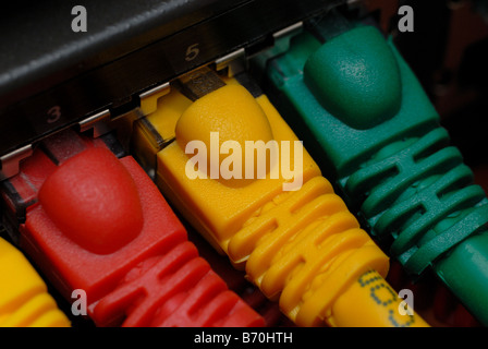 Brightly colored ethernet cables plugged into a network router Stock Photo