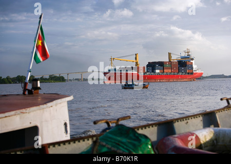 Suriname, Paramaribo. View from deserted ship in Suriname river, in background container ship and Wijdenbosch bridge. Stock Photo