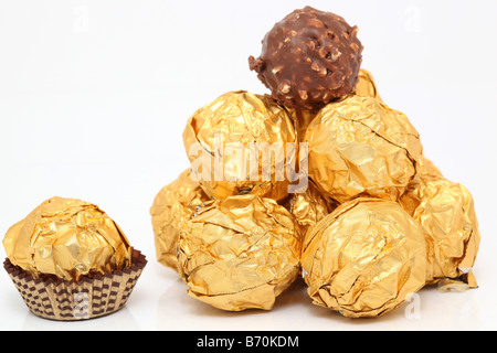 closeup gold wraped chocolate balls pyramid isolated on white background Stock Photo