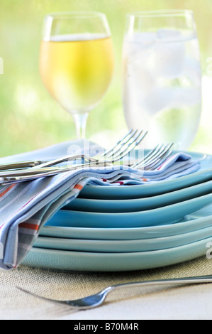 Table setting with stack of plates and cutlery Stock Photo