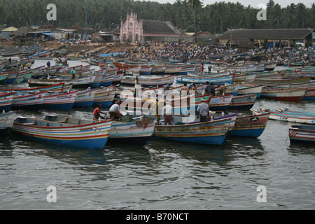 Thousands of fishing boats with local fishermen at the fish harbour engaged in fishing business with church in background Stock Photo