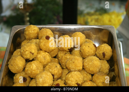 Laddu a small round shape yellow color traditional sweet in Kerala India usually homemade served to guests on wedding buffets kids party food silver Stock Photo