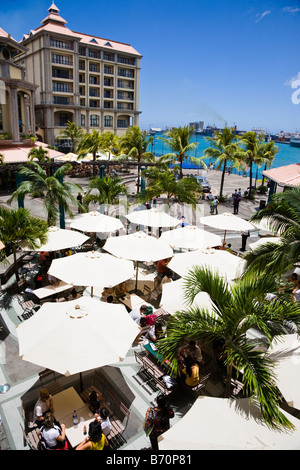 Caudon Waterfront at the harbour in Port Louis Mauritius with street cafes with umbrellas for shade Stock Photo