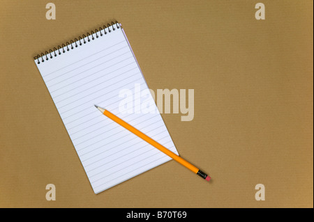 Blank reporters notebook and pencil on a brown paper background Stock Photo