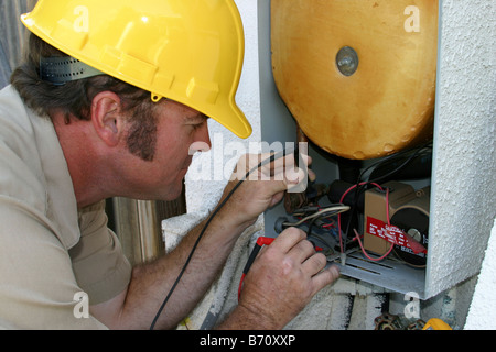 An air conditioning repairman testing a heat recovery unit Stock Photo