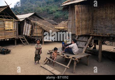 Hmong Children or Family Outside their Traditional Bamboo & Grass Houses in the Upland Lao Village of Khamu, Luang Prabang, Laos Stock Photo