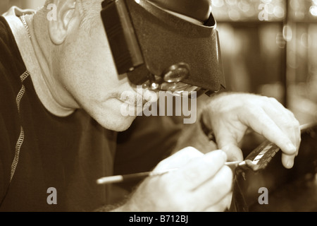 a master craftsman building a replica of a ship in sepia Stock Photo