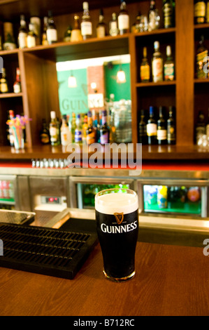 A glass of Guinness beer served in an Irish pub Stock Photo