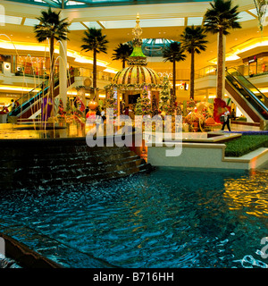 Gardens Shopping Mall or center Xmas decorations in central area with exotic Father Christmas stand & fountains & palm trees Stock Photo