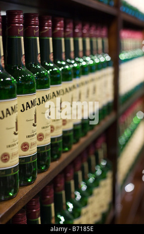 Irish Whiskey on Display vertical: A massive display case of identical bottles of Jameson triple distilled Irish Whiskey Stock Photo